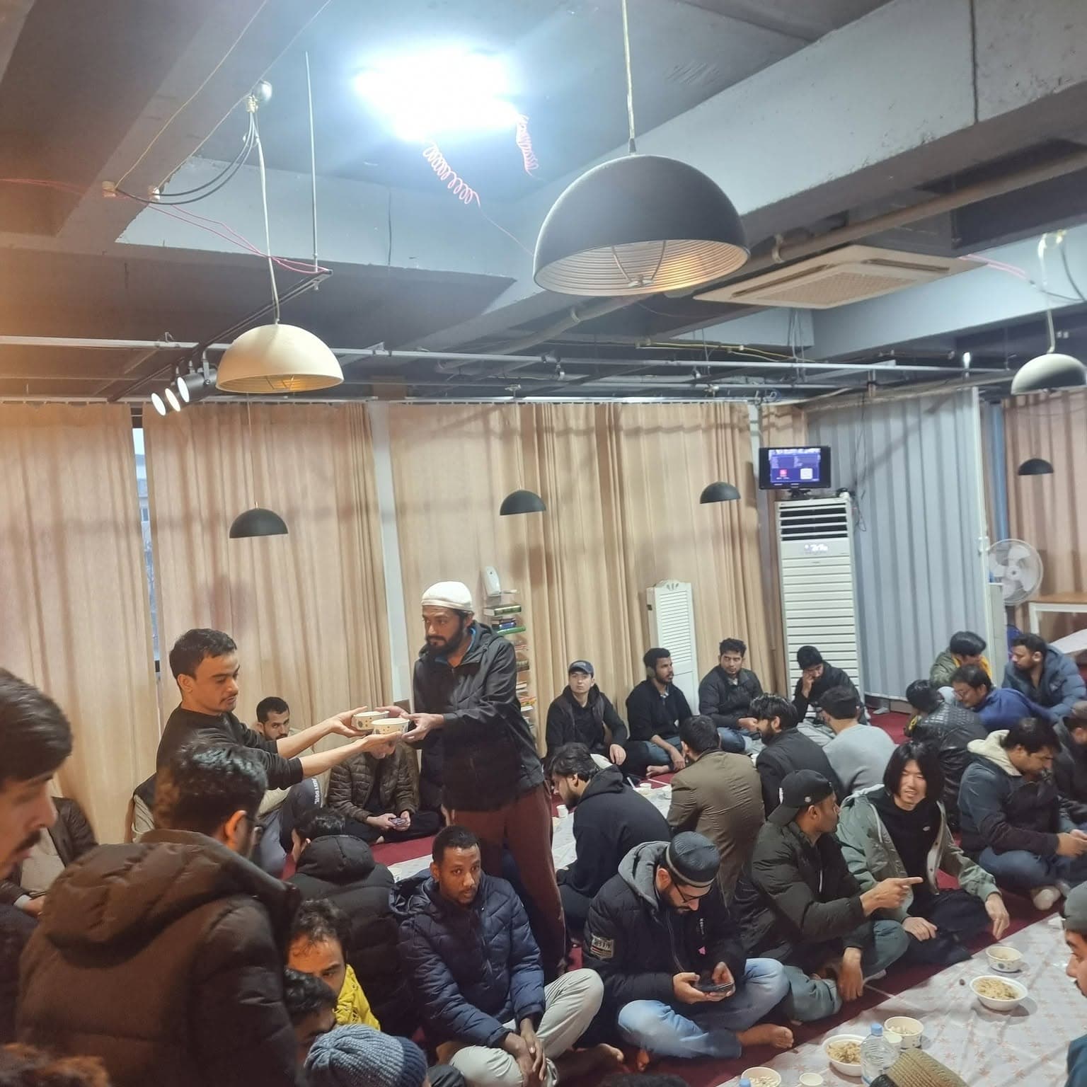 Monthly community gathering sharing a meal at the masjid